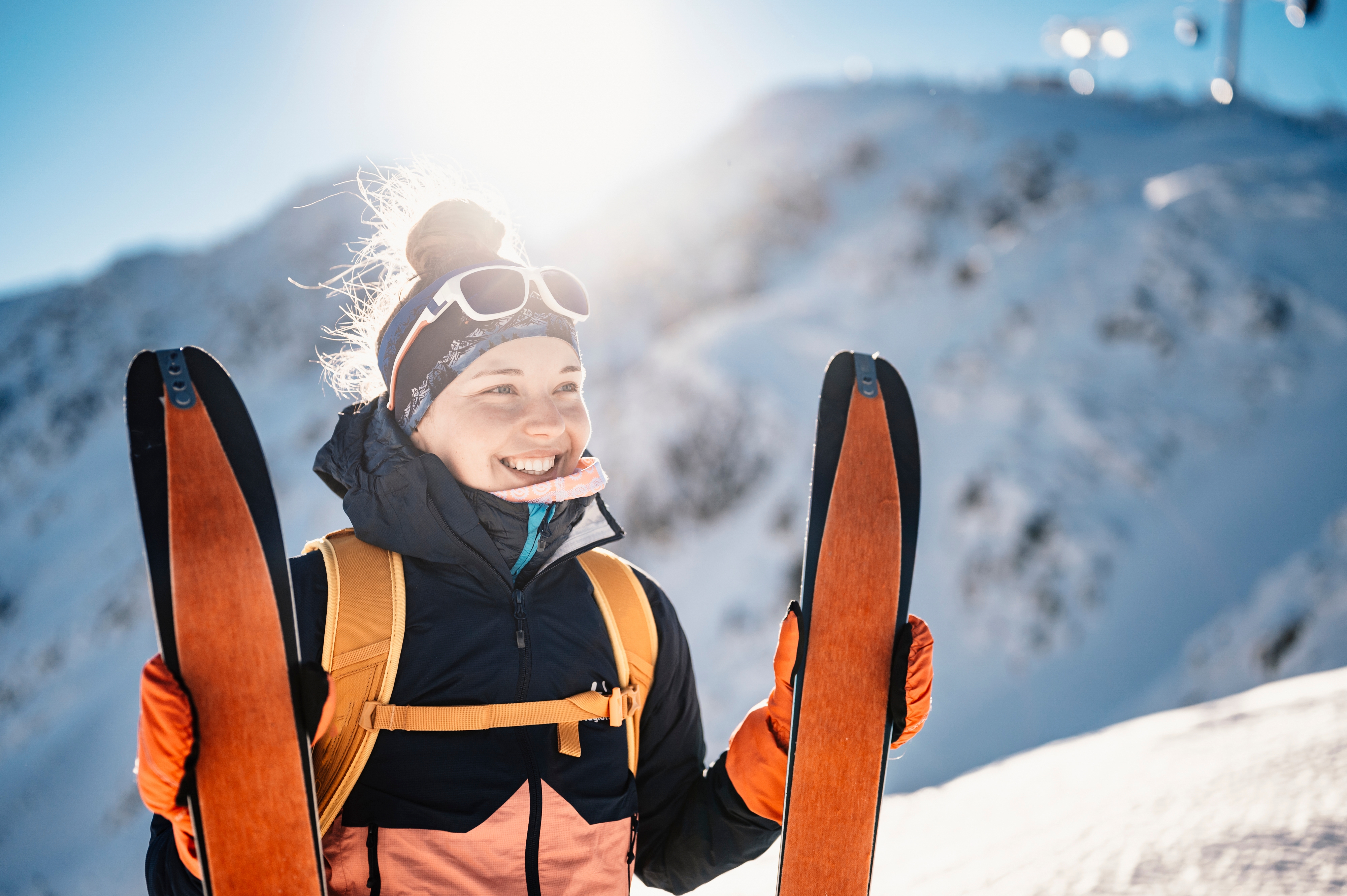 lachende Frau mit Ski in der Hand